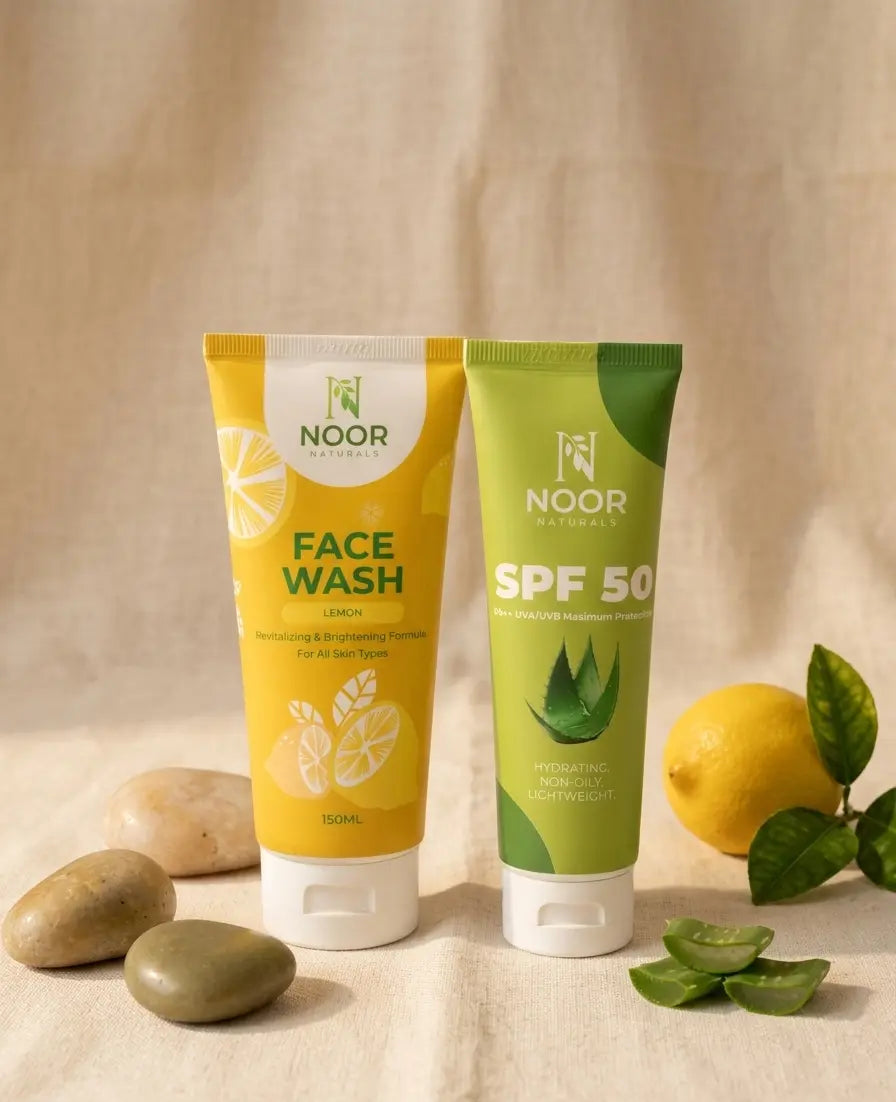 Two tubes of NOOR skincare products on a neutral background with lemons and stones.